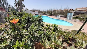 Una piscina circondata dal verde, con un cielo sereno.