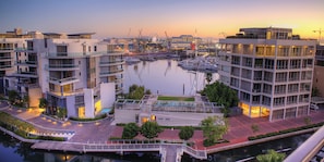 A marina with boats, modern buildings, and a sunset. - One Bedroom Apartment - Fully Equipped and Design Furnitures (Cape Town)