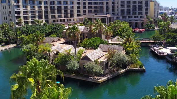 A hotel with multiple floors, outdoor pools, and lush greenery. - Two Bedroom Apartment - Fully Furnished and Equipped (Cape Town)