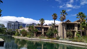 A resort with a pool, palm trees, and modern buildings.