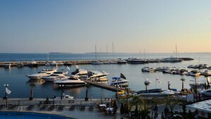 A marina with multiple yachts docked, a swimming pool, and a dining area with tables and chairs. - Sunny Beach Retreat - 2-bedroom Apartment (Sunny Beach)