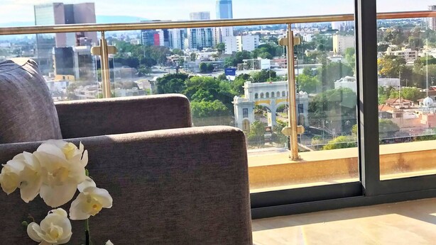 A high-rise room with a large window offering a city view. - Minerva Zone Apartment Super Vista Fully Equipped Pool 3 Rec 6pp tv Wifi Aa (Guadalajara)