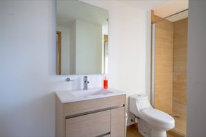 A modern bathroom with a white sink, a mirror, and a shower area. - Minerva Zone Apartment Super Vista Fully Equipped Pool 3 Rec 6pp tv Wifi Aa (Guadalajara)