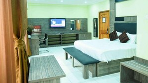 A modern hotel room with a bed, bench, TV, and a desk. - Best Western Plus Mydas Hotel (Owo)