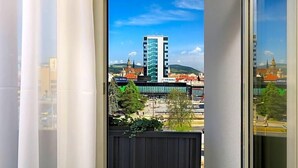 A view from a window with a cityscape in the background, including a tall building and a bank. - Centrum (Kosice)