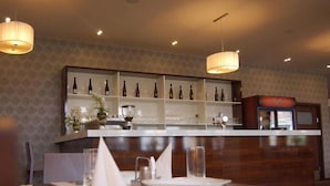 A restaurant interior with a bar area, white shelves with bottles, and a Coca-Cola refrigerator. - Centrum (Kosice)