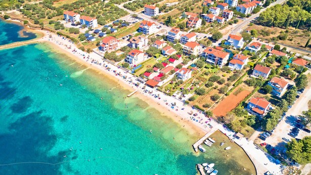 An aerial view of a coastal town with a beach, residential buildings, and a marina. - Secluded Pool Villa Sofija near Zadar, Prkos, Croatia (Prkos)