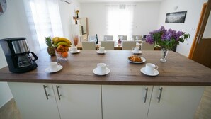 A dining area with a wooden table set for breakfast, including fruits, pastries, and cups. - Secluded Pool Villa Sofija near Zadar, Prkos, Croatia (Prkos)
