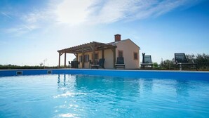 A swimming pool with a covered area and lounge chairs, surrounded by a house with a clear blue sky. - Secluded Pool Villa Sofija near Zadar, Prkos, Croatia (Prkos)