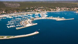 An aerial view of a marina with numerous boats docked, surrounded by a coastal town with houses and a lighthouse. - Secluded Pool Villa Sofija near Zadar, Prkos, Croatia (Prkos)