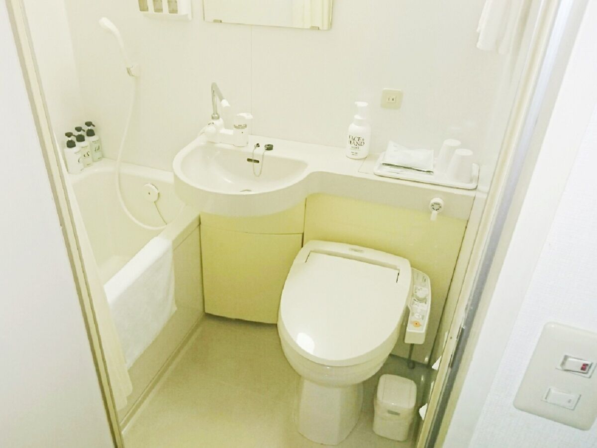 A compact bathroom with a toilet, sink, and bathtub.