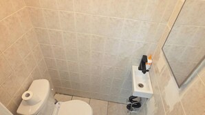 A bathroom with a toilet, a sink, and a shower area. - Private Suite & Bath  10 min JFK  Flexible Terms (Richmond Hill)
