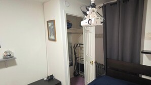 A bedroom with a bed, a bedside table, a shelf with a disco ball, a picture on the wall, and a door leading to another room. - Private Suite & Bath  10 min JFK  Flexible Terms (Richmond Hill)
