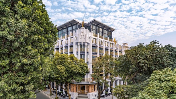 A multi-story hotel with a central courtyard, surrounded by lush greenery. - Capella Hanoi (Hanoi)