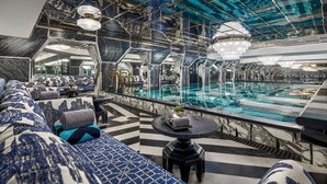 A luxurious interior with a pool, seating area, and modern decor. - Capella Hanoi (Hanoi)