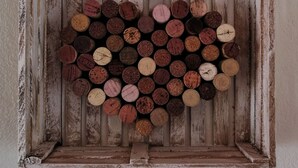 A rustic wooden frame with a heart-shaped arrangement of corks. - Casa Dalima, home between mountains (Villa de leyva)