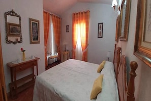 Una habitación de hotel con dos camas, un escritorio, una silla y una mesita.