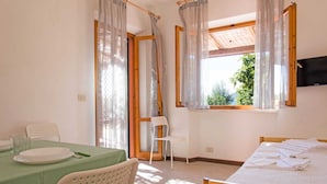 Una habitación con una cama, una mesa con platos y una silla.
