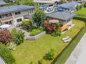 A residential property with solar panels, a well-maintained lawn, and a small deck.