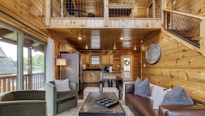 A cozy cabin interior with a wooden interior, a dining area, and a kitchen. - TWO Cabins!  Sleeps 24, Themed Bunk Rooms for The Kids, Hot Tubs, Mountain Views (Sevierville)