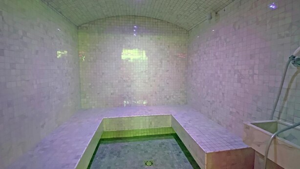 Un baño pequeño con azulejos, una zona de ducha y un lavamanos.