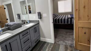 A modern bathroom with a large mirror, dual sinks, and a vanity. - Lake View Modern House with Beautiful Sunsets! (Page)