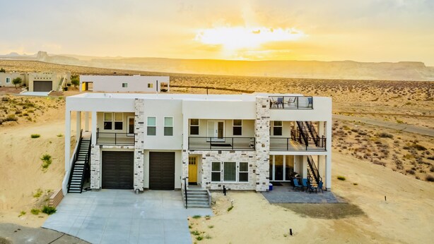 A modern two-story building with a flat roof, a staircase, and a balcony. - Lake View Modern House with Beautiful Sunsets! (Page)