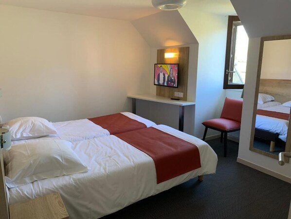 A hotel room with a bed, a desk, a chair, a television, and a mirror. - Alba Hotel Lac d'Orient (Mesnil-Saint-Pere)