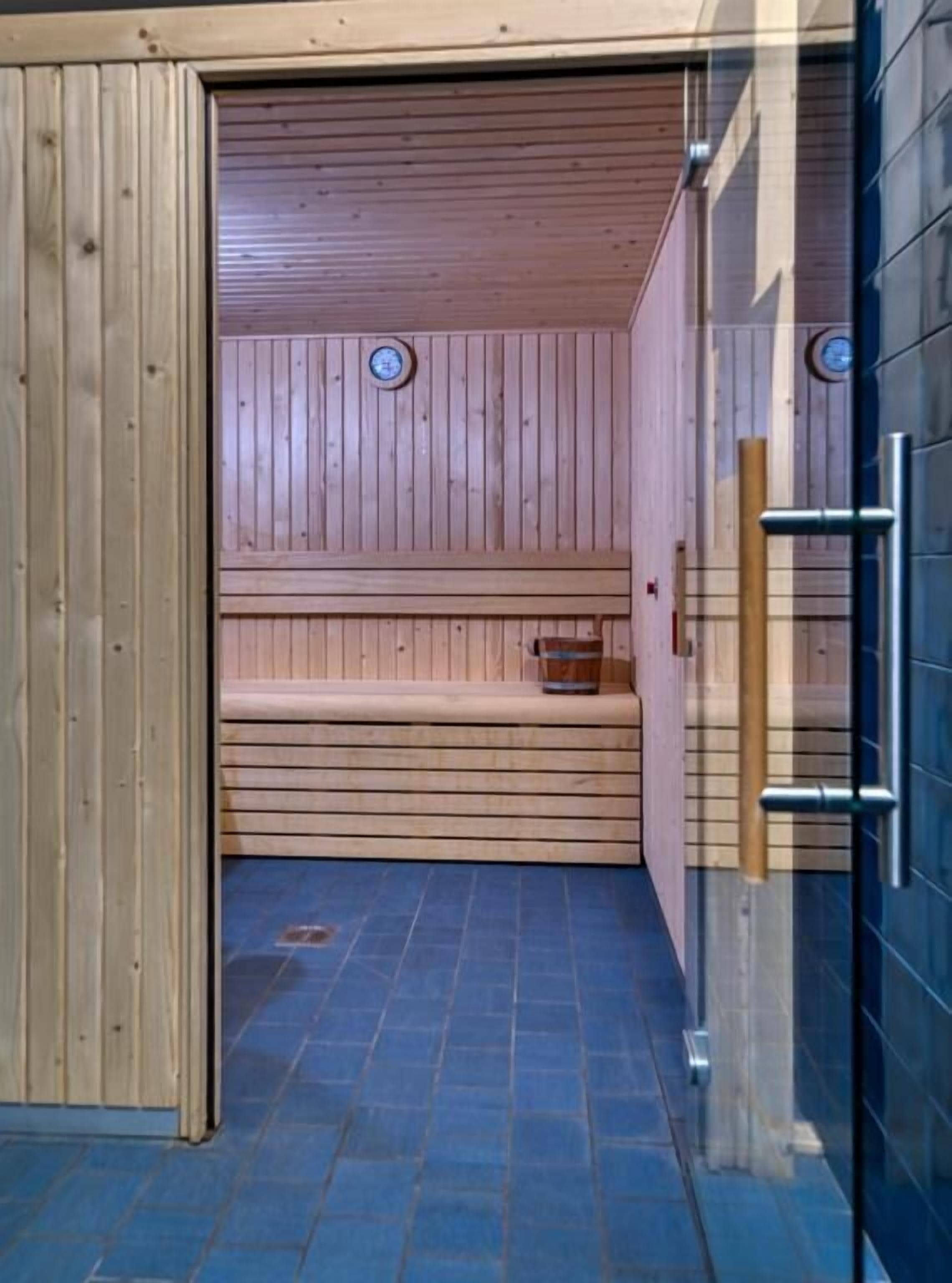 A sauna with wooden benches and a tiled floor.