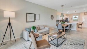 Un salon moderne comprenant un canapé, une table basse et un coin repas avec des chaises et une table.