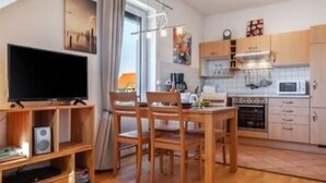 A compact living space with a dining area, kitchenette, and a television. - Waldstr. 34 Wo.05 - Wo.05 (Kühlungsborn)
