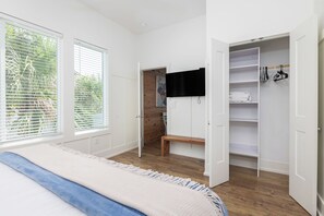 A bedroom with a bed, a bench, a wardrobe, and a television. - Exquisite Oceanfront Oasis: Immerse in Luxury with Pool & Putting Green! (Folly Beach)