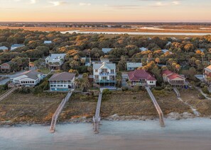 An aerial view of a coastal residential area with houses, a beach, and a marshy landscape. - Exquisite Oceanfront Oasis: Immerse in Luxury with Pool & Putting Green at this (Folly Beach)