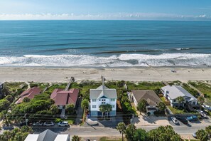 A coastal residential area with houses, a beach, and a clear view of the ocean.
