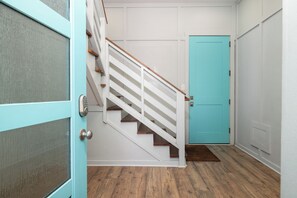 A staircase with white railings and wooden steps leading to a turquoise door. - Exquisite Oceanfront Oasis: Immerse in Luxury with Pool & Putting Green! (Folly Beach)