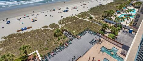 A beach resort with a pool area, beach access, and ocean views.