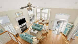 A spacious living room with a fireplace, multiple seating areas, and a staircase. - Elegant, Luxury Home w/Private Pool & Easy Beach Access-North Myrtle Beach Rental (North Myrtle Beach)