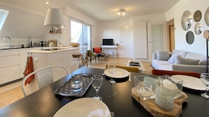 A modern living space with a kitchen, dining area, and seating area.