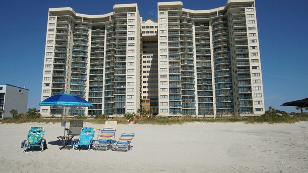 A high-rise hotel with multiple balconies and a beachside location. - Oceanfront 4BR corner condo with balcony views, pools, lazy river, steps to Main Street in NMB. (North Myrtle Beach)