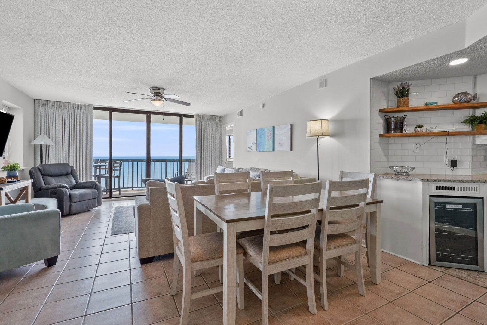 A modern living room with a dining area, a kitchen, and a balcony with a view.