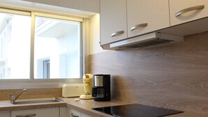 A modern kitchen with a window, stainless steel appliances, and wooden countertops.
