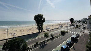 A beach view with a road and buildings in the foreground.