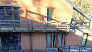 A two-story building with a wooden balcony, brick walls, and numbered windows.