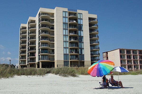 A multi-story hotel with balconies and large windows, located near a sandy beach. - Great side-view family condo rental w/pool, hot tubs in North Myrtle Beach (North Myrtle Beach)