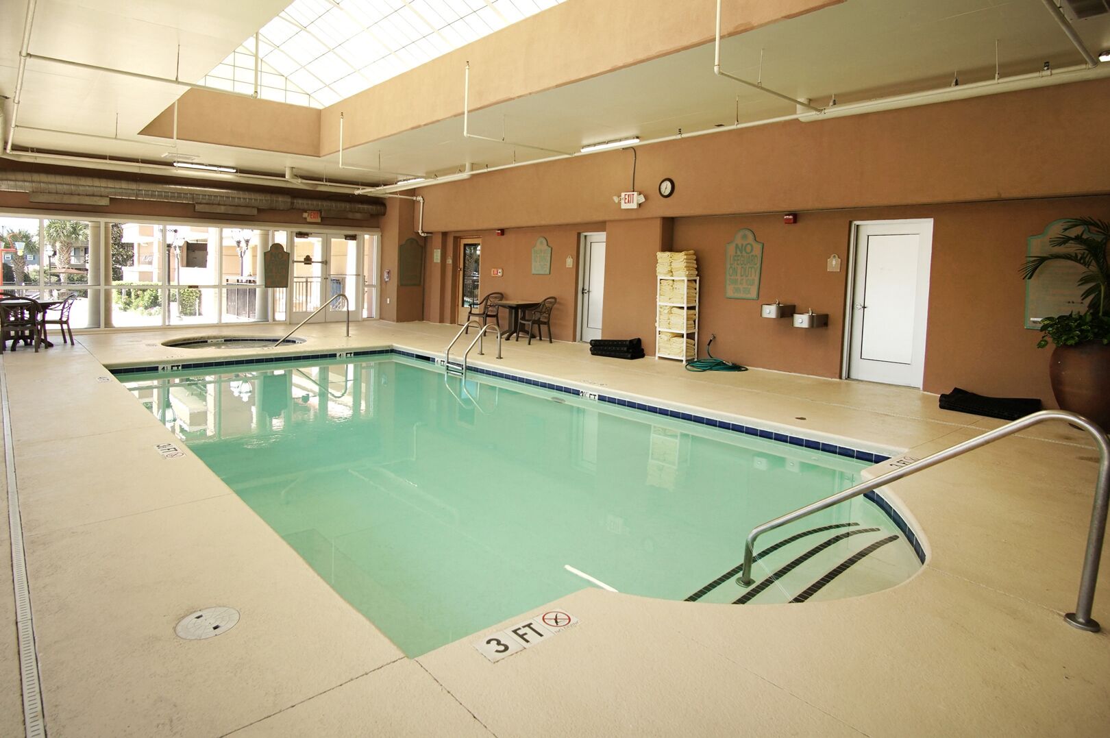 Une piscine intérieure avec des lignes de démarcation bien visibles, un poste de surveillance pour les sauveteurs et un panneau indiquant qu’aucun sauveteur n’est en service.