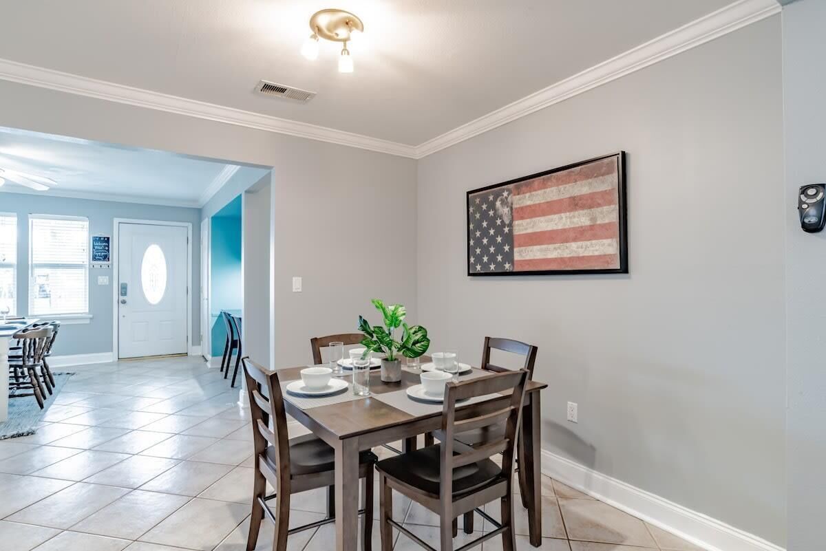 Een eethoek met een tafel voor vier personen, een potplant en een Amerikaanse vlag aan de muur.