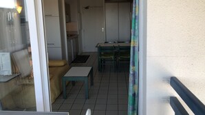 Une cuisine compacte équipée d’un réfrigérateur, d’une cuisinière et d’un évier. On y trouve également une petite table à manger avec des chaises.
