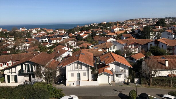 Un quartier résidentiel situé sur la côte, caractérisé par des maisons blanches et des toits recouverts de tuiles rouges.