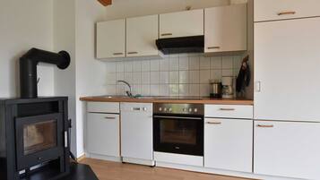 Kjøleskap, ovn, oppvaskmaskin og høy barnestol