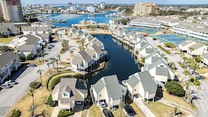 Zona residencial costera con casas, un puerto deportivo y un gran hotel con varias piscinas.